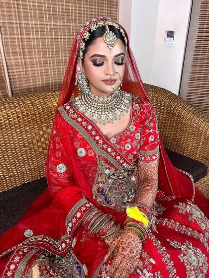 A full view of this gorgeous red bridal look. The makeup is designed to be long-wearing and photogenic, with a focus on enhancing the bride's features with a touch of shimmer and perfectly defined lips.