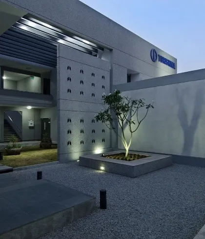 An evening view of a courtyard at the Torishima Pumps campus. Thoughtful architectural lighting enhances the landscape design and highlights the building's form after sunset. We believe that good design considers the building's ambiance and functionality around the clock.