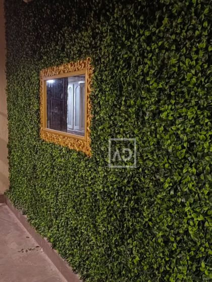 This outdoor vertical garden wall was designed to cover a plain exterior wall. I incorporated a decorative mirror with a gold frame, showing how you can integrate other design elements directly into the green wall.