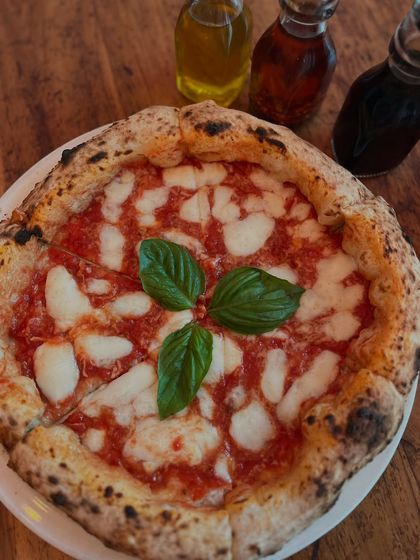 Our Margherita, sitting next to our house-made infused oils. A little drizzle of chili or garlic oil takes it to the next level.