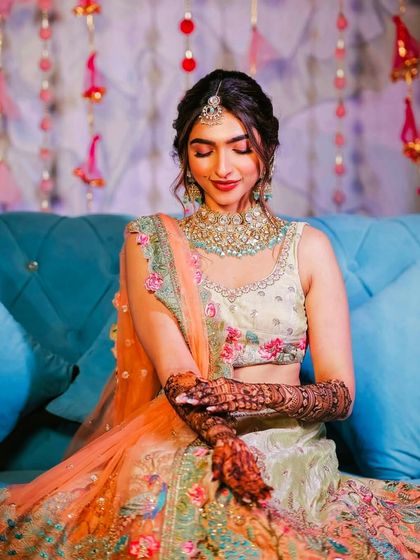 A bride looking down at her hands, a classic pose that beautifully highlights her intricate bridal henna.