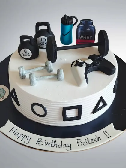 A cake for someone who loves both the gym and gaming. This design features fondant dumbbells, kettlebells, and a protein shaker alongside a PlayStation controller.