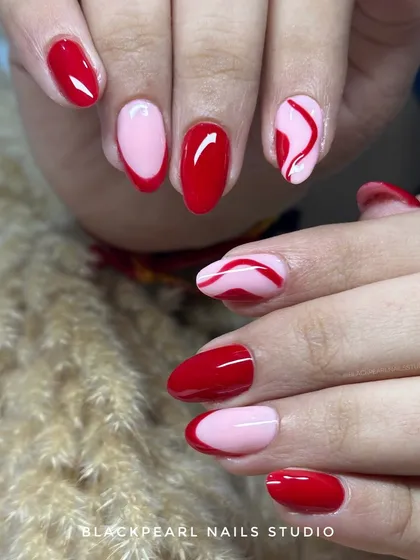 A playful mix of hot red and soft pink. This design features solid colors, a modern French tip, and a hand-painted swirl accent nail for a bold and fun look.