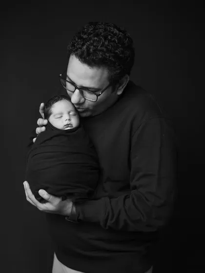 A father's gentle kiss for his newborn. I capture these quiet, tender moments in classic black and white to create timeless and emotional portraits that focus purely on the bond between parent and child.