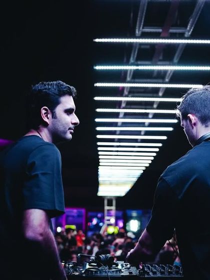 Two DJs in a back-to-back set, focused on their mix. I love creating these collaborative moments, where artists can feed off each other's energy to the crowd's delight.