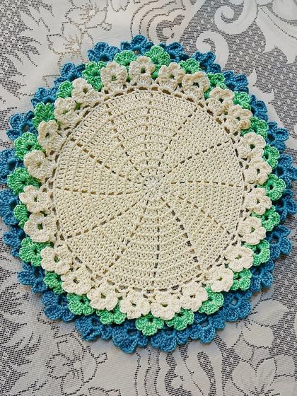 This placemat features cool tones of blue, green, and cream in its layered floral design. It’s perfect for creating a calm and serene table setting.