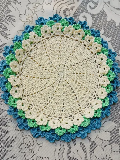 This placemat features cool tones of blue, green, and cream in its layered floral design. It’s perfect for creating a calm and serene table setting.