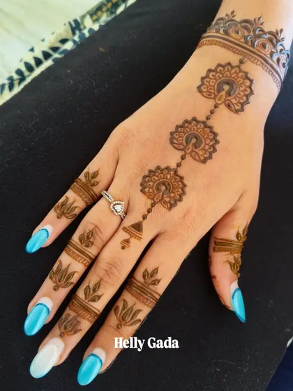 A minimalist design for a bride-to-be. A central hanging motif with delicate lotuses on the fingers. It's chic, stylish, and modern.