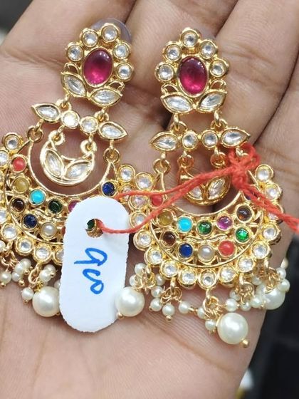 A pair of Navratan chandbali earrings with pearl drops. The mix of nine different coloured stones makes them versatile enough to be worn with many outfits.