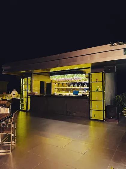 The bar area is a central feature of this rooftop cafe project. We designed it with clean lines, back-lit shelving to highlight the glassware, and an integrated planter on top, blending functionality with natural elements.