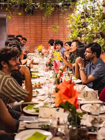 A long shot of our community table during the wine tasting event, filled with engaged and happy guests.