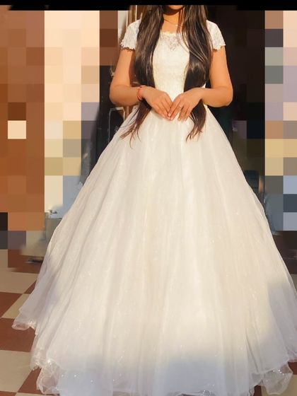 A front view of the white ball gown, featuring a delicate lace bodice and cap sleeves. A perfect rental for a classic and elegant look.