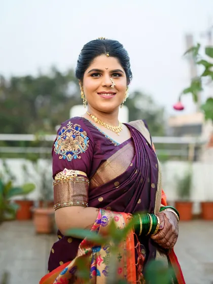 A full portrait of the bride in her gorgeous purple saree with an embroidered blouse. The makeup complements the outfit without overpowering her natural features.