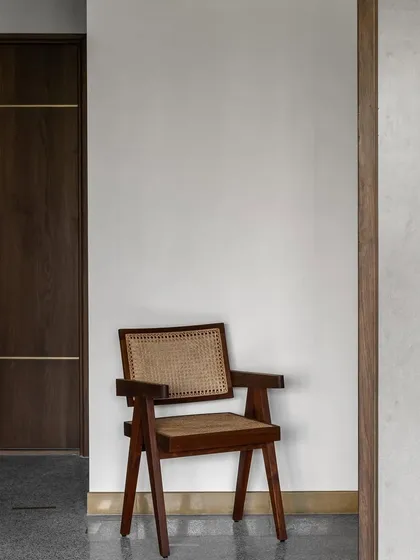 A detail from our '9PM' project, showcasing a beautifully crafted wooden chair with a cane back. This piece reflects our belief in timeless design and quality craftsmanship, where every object in a space has its own story.