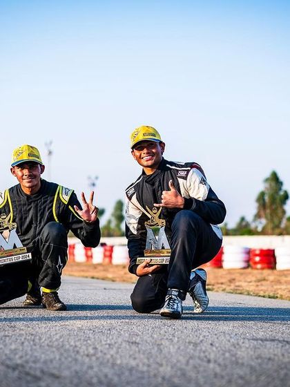 Two of our drivers posing with their trophies after a successful race weekend. Their smiles show the joy and satisfaction that comes from achieving their goals.