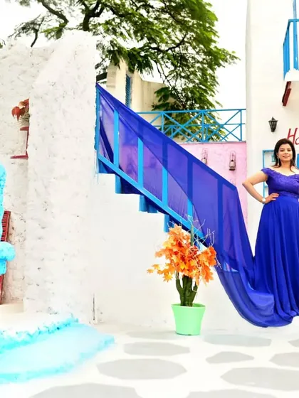 Our royal blue trail gown looks stunning against the white and blue architecture of this Santorini-themed set. The long train drapes beautifully down the stairs for a dramatic effect.