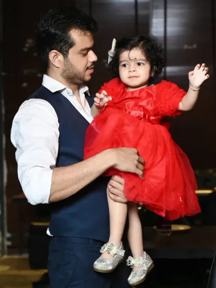 A father holds his daughter, who is looking curiously off-camera. I capture both posed and candid portraits of children.