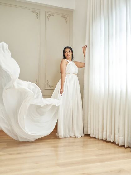 Meet 'Paul', a Grecian-inspired white gown. It has a bold criss-cross halter neck and a breezy georgette skirt that flows beautifully with every movement.