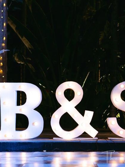 Your love story in lights. We use large, illuminated marquee letters with the couple's initials to create a personalized and highly photogenic focal point.