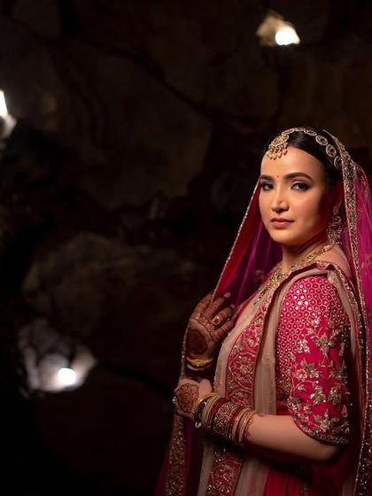 A full-length portrait of the bride in a cave-like setting, the unique lighting creating a moody and glamorous feel.