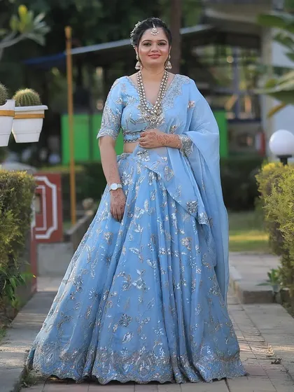 A full-length shot in an outdoor setting. The soft blue color and radiant makeup look stunning in natural light.