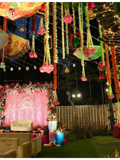 A closer view of the evening stage, with a shimmering pink backdrop and colorful hanging decor. This setup is perfect for a lively Mehndi or Sangeet night.