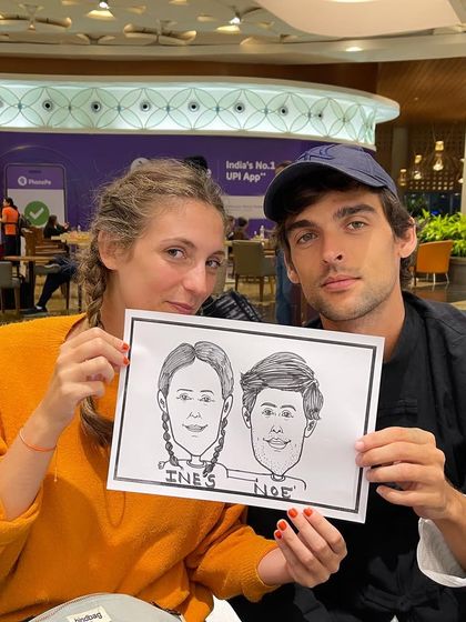 An international couple with their caricature, a unique souvenir from their time in Mumbai.