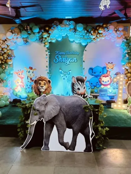 I brought the jungle to life for this first birthday party with a large stage setup. It features a variety of life-sized, friendly animal cutouts like an elephant, tiger, and zebra, all set against a lush green backdrop with a balloon arch to complete the safari theme.