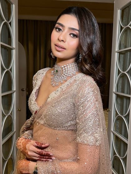 This pose highlights the beautiful V-neck of the blouse and the way the makeup enhances the bride's features. It's a look that is both sexy and elegant.
