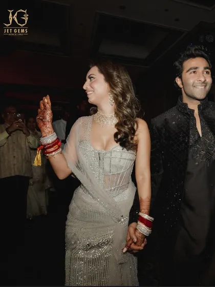 A candid moment of joy. Alekha Advani, holding hands with Aadar Jain, shines beautifully in her custom diamond necklace, a piece designed to capture the happiness of her celebration.