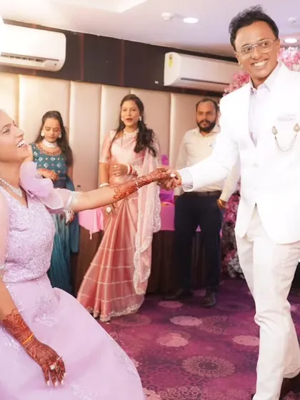A fun moment from an engagement party, with the groom leading his bride to the dance floor.