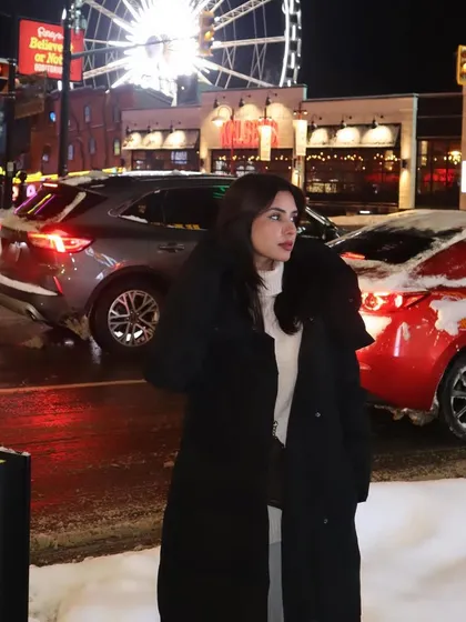 A tighter shot of my winter outfit at Niagara Falls, focusing more on my expression and the falling snow.