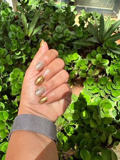 A beautiful outdoor shot of the gold glitter and foil nails, shining in the sunlight.