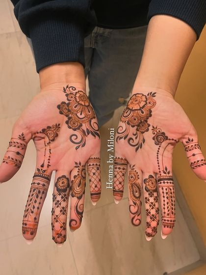 A minimal design for an engagement, with a simple floral motif on the palm and detailed fingers.