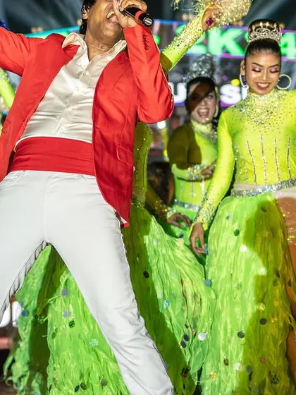 Jumping with joy and energy at the Tajpur show. My red and white outfit stood out against the vibrant green costumes of my dancers.