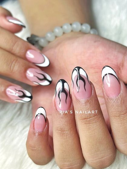 A cool twist on a French manicure with black and white fire art. Edgy and super stylish.