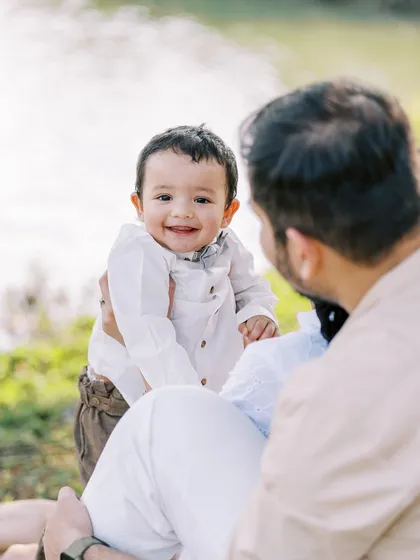 A happy smile from the birthday boy, held by his parents. Capturing these moments of connection is what it's all about.