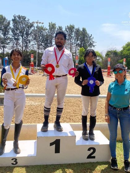 Another angle of our riders on the podium, showcasing the medals and ribbons they earned through their hard work.