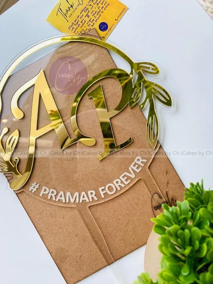 A premium glass-like acrylic topper with initials "A" and "P" and the phrase "#PRAMAR FOREVER," perfect for modern weddings.
