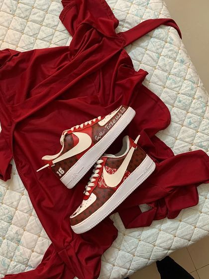 A flat lay of the Manchester United sneakers with a matching red outfit. It's always fun to see how clients will style their custom kicks.