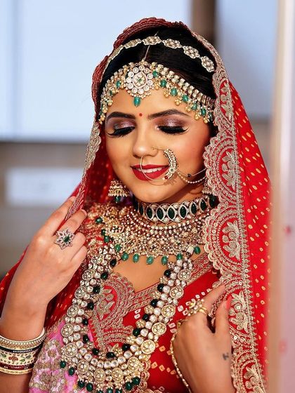 This stunning bridal set features multiple layers of Kundan and emerald green beads, creating a look of pure opulence. It includes the choker, rani haar, matha patti, and nath.