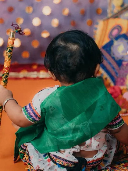 Getting ready to play Garba with her dandiya sticks. This shot captures a quiet moment before the dance begins.