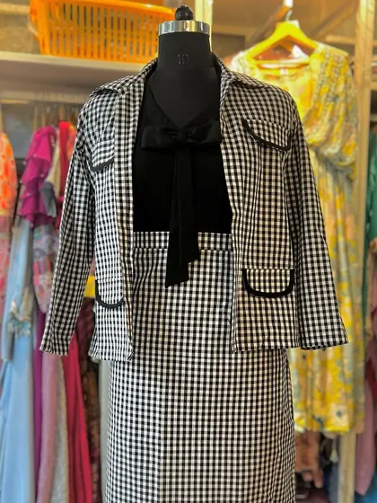 This checkered blazer and skirt set is my modern take on professional attire. Paired with a simple knot shirt, it’s a versatile outfit that transitions seamlessly from a formal meeting to a chic evening out, offering a look that is both sharp and stylish.