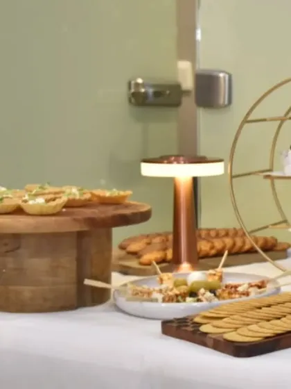 An elegant corner of our setup for Clinic Dermatech, featuring tiered stands with canapés and a warm, inviting table lamp to create a cozy ambiance.