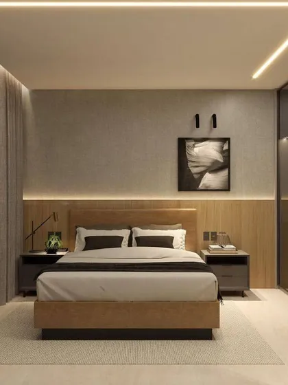 A contemporary bedroom with a masculine edge, featuring a wood-paneled wall, a leather-finish bed, and a sleek glass wardrobe. The linear LED lighting on the ceiling adds a modern touch.