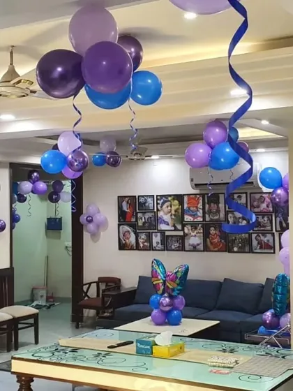 Simple yet beautiful butterfly-themed balloon decorations for a living room, including bunches on the ceiling and a centerpiece for the table.
