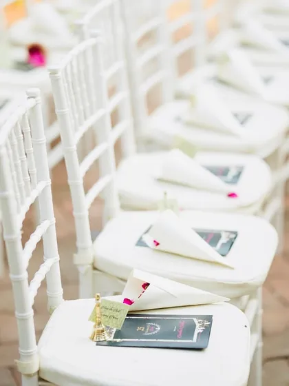 A well-prepared seat makes every guest feel welcomed. For this elegant ceremony, each chair was set with a program and a paper cone filled with fresh rose petals, ready for showering the couple with blessings.