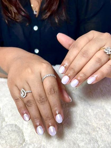 A simple and elegant pearlescent white manicure. This 'glazed donut' look is perfect for a clean and trendy style.