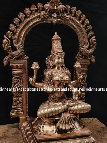 A beautiful bronze Mahalakshmi statue, framed by an ornate Prabhavali (arch). This is a perfect idol for Akshaya Tritiya, a day that celebrates endless prosperity.