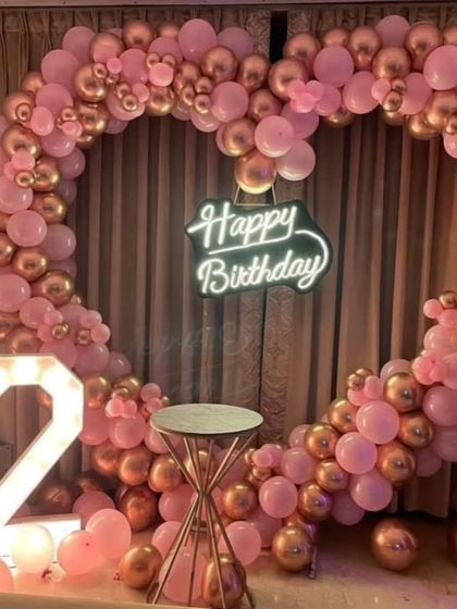A close-up of the heart-shaped pink and rose gold balloon arch for a 2nd birthday.